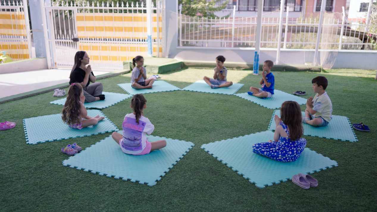 Teoti Anaokulları bahçesinde çocuklarla yapılan grup hareket ve yoga etkinliği